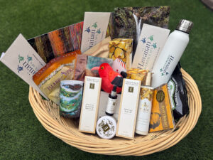 Basket containing Hawaiian Experience Spa gift cards, Eminence Organic skin care products, Hawaiian art and other items