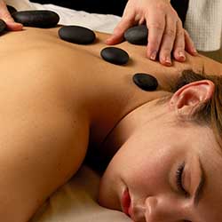 Client receiving hot stone massage in Phoenix, AZ spa